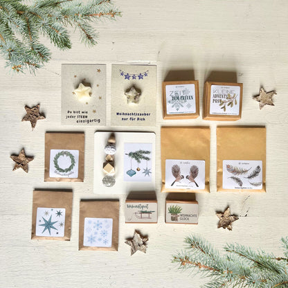 foodigence Adventskalender mit 12 liebevoll zusammengestellten Überraschungen rund um Natur, Weihnachten und Nachhaltigkeit, darunter Saatkugeln, Vogelfutter, Sonnenfänger und kleine Geschenkideen