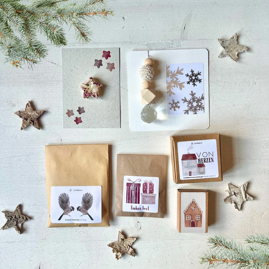 foodigence zusammengestelltes Geschenkset mit sechs winterlichen Kleinigkeiten in roten und rosafarbenen Designs als Adventskalender-Füllung oder Nikolausgeschenk