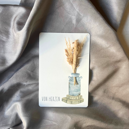 Postkarte von foodigence mit Sträußchen aus Wildgräsern "von Herzen" vor einem Satintuch