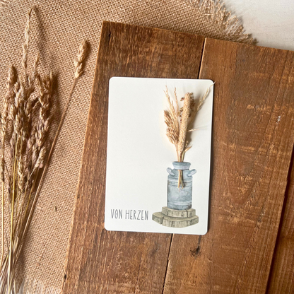 Postkarte von foodigence mit Sträußchen aus Wildgräsern "von Herzen" auf einer Holzplatte designt