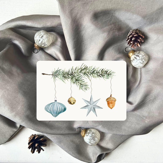 Weihnachtspostkarte von foodigence mit türkisen Weihnachtselementen in aquarell-Design vor einem grauen Samttuch abgebildet 