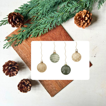 Karte mit vier hängenden Weihnachtskugeln in grün/beige Design aus dem Weihnachtspostkarten Set von foodigence