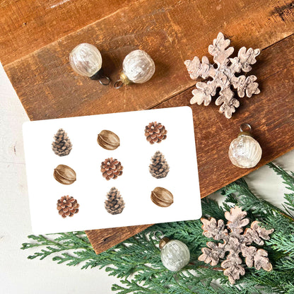 Karte mit angeordneten Tannenzapfen und Walnüssen iner einer ästethischen Weise aus dem Weihnachtspostkarten Set von foodigence