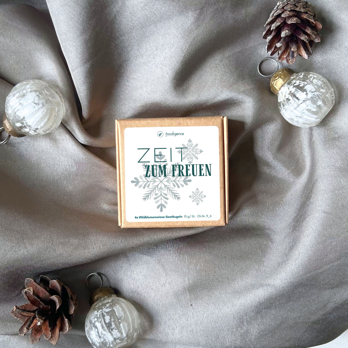 Saatkugeln / Samenbomben mit Wildblumensamen von foodigence winterliches Design für Weihnachten "Zeit zum Freuen" mit Schneeflocknen in türkis - Set mit 4 Saatkugeln - fotografiert vor grauem Samttuch