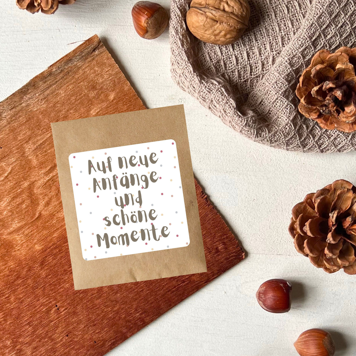 Samentütchen dekoriert mit Tannenzapfen auf dem steht: "Auf neue Anfänge und schöne Momente" um Vreschenken von foodigence