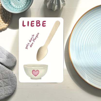 Postkarte mit echtem Holzlöffelneben Teller liegend